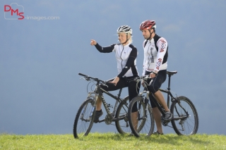 A couple with their mountain bikes on a meadow in autumn