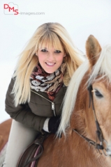 Close-up of a young, pretty woman with a Haflinger horse in the snow in winter
